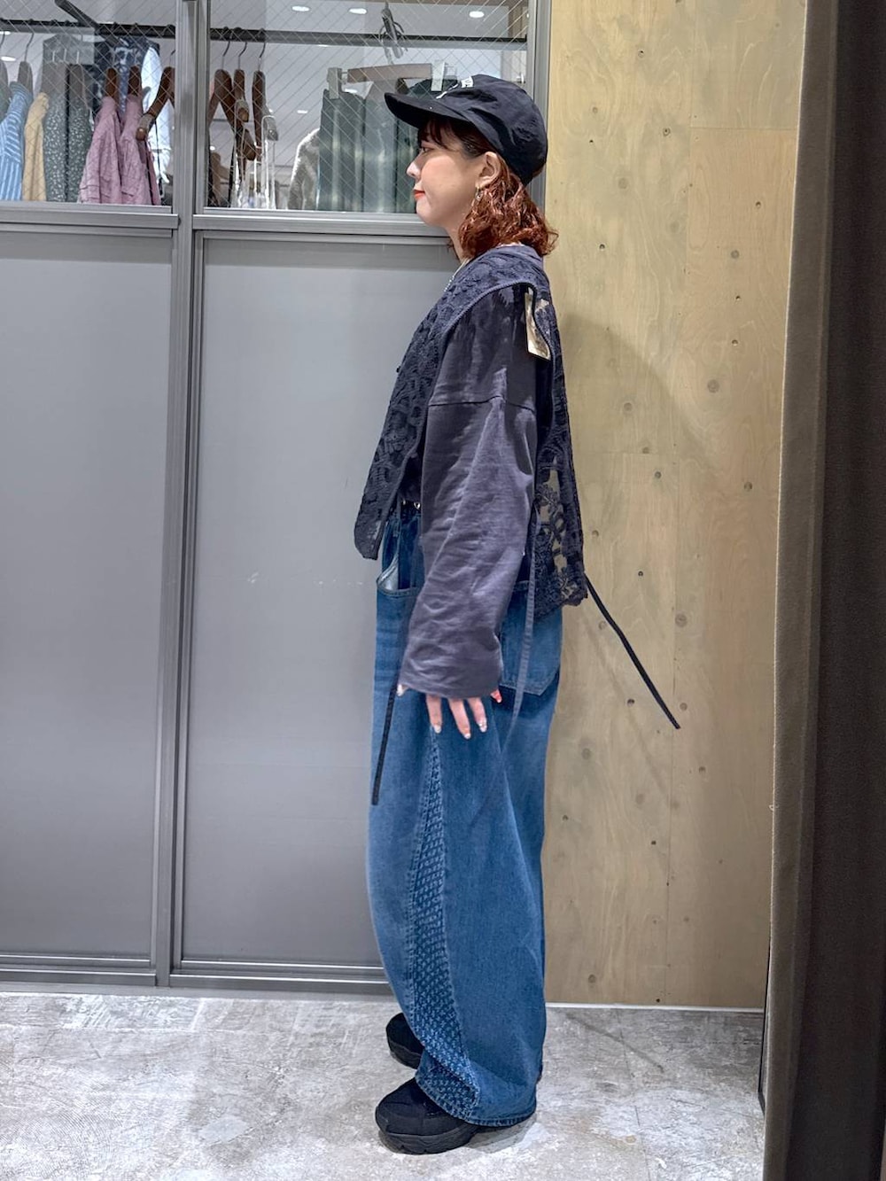 グレー系のTシャツ/カットソー、ブルー系のデニムパンツ、ブラック系のベストを着用したレディースの冬コーディネートの3枚目の写真