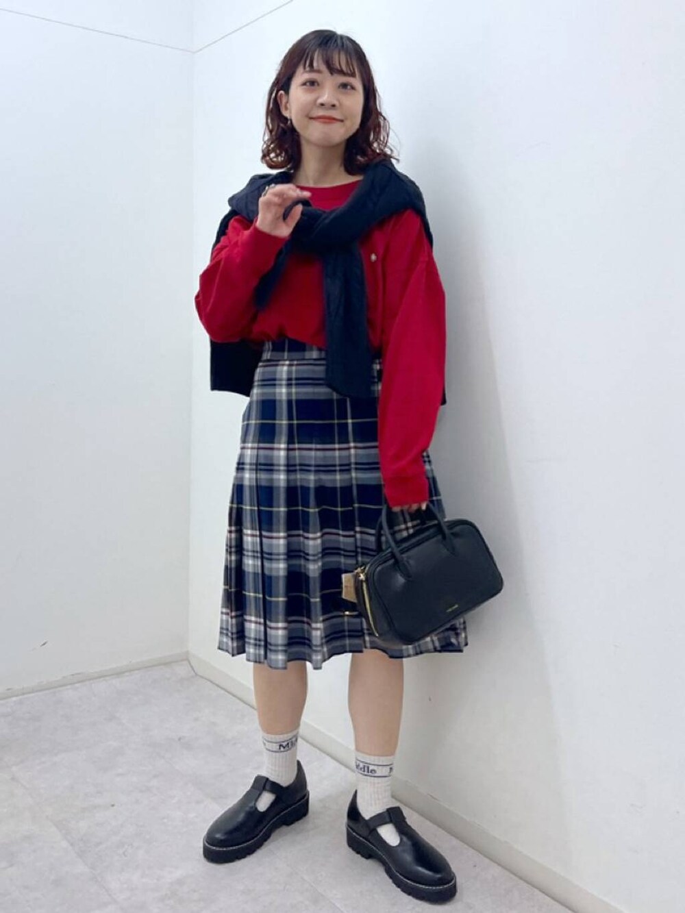 ブラック系のその他シューズ、ブラック系のショルダーバッグ、レッド系のTシャツ/カットソーを着用したレディースの冬コーディネートの4枚目の写真