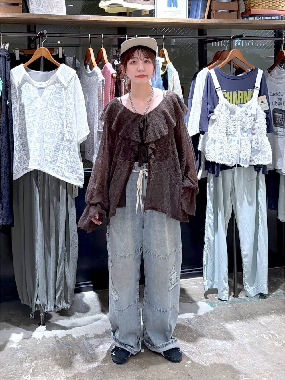 ブラウン系のカーディガン/ボレロ、ブルー系のデニムパンツ、ブラック系のキャップを着用したレディースの秋コーディネートの5枚目の写真
