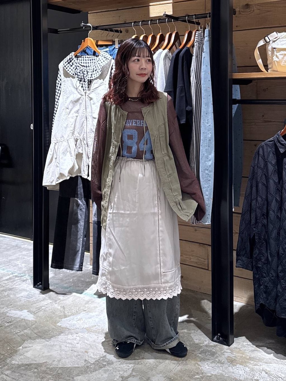 グリーン系のベスト、ブルー系のデニムパンツ、ベージュ系のTシャツ/カットソーを着用したレディースの春コーディネートの2枚目の写真