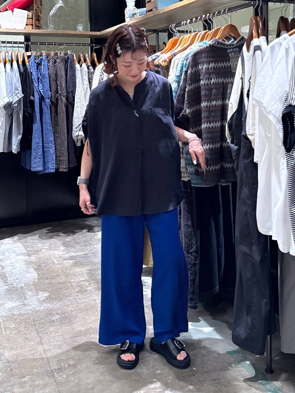 グレー系のタンクトップ、ブラック系のサンダル、ブルー系のその他パンツを着用したレディースの夏コーディネートの2枚目の写真