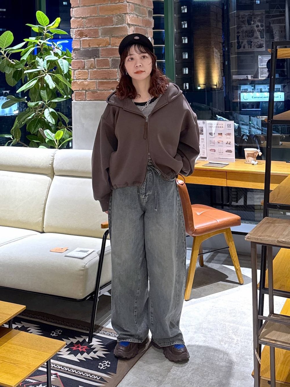 ブラウン系のスニーカー、ブルー系のデニムパンツ、ブラウン系のパーカーを着用したレディースの冬コーディネートの3枚目の写真