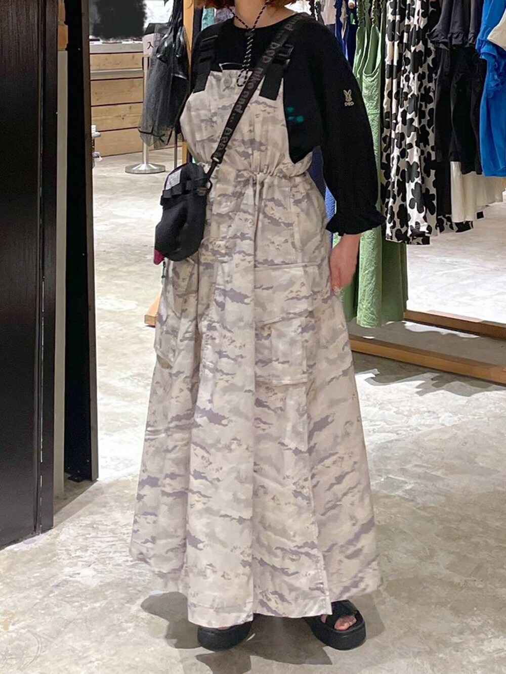 ブラック系のサンダル、ブラック系のTシャツ/カットソー、グリーン系のジャンパースカートを着用したレディースの春コーディネートの7枚目の写真