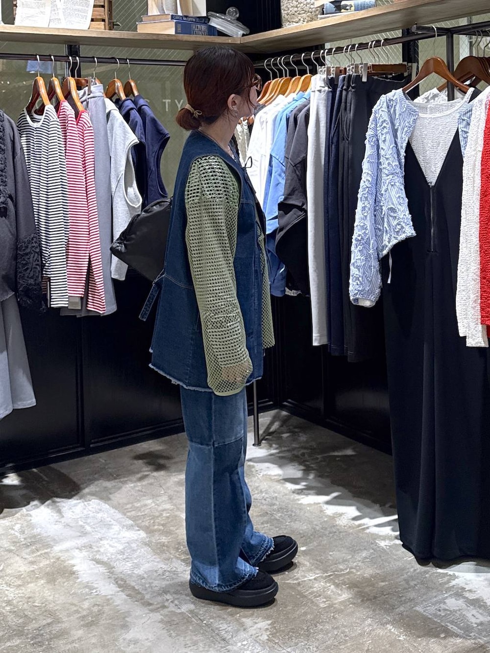 ブルー系のベスト、ブラック系のローファー、ブルー系のデニムパンツを着用したレディースの春コーディネートの4枚目の写真