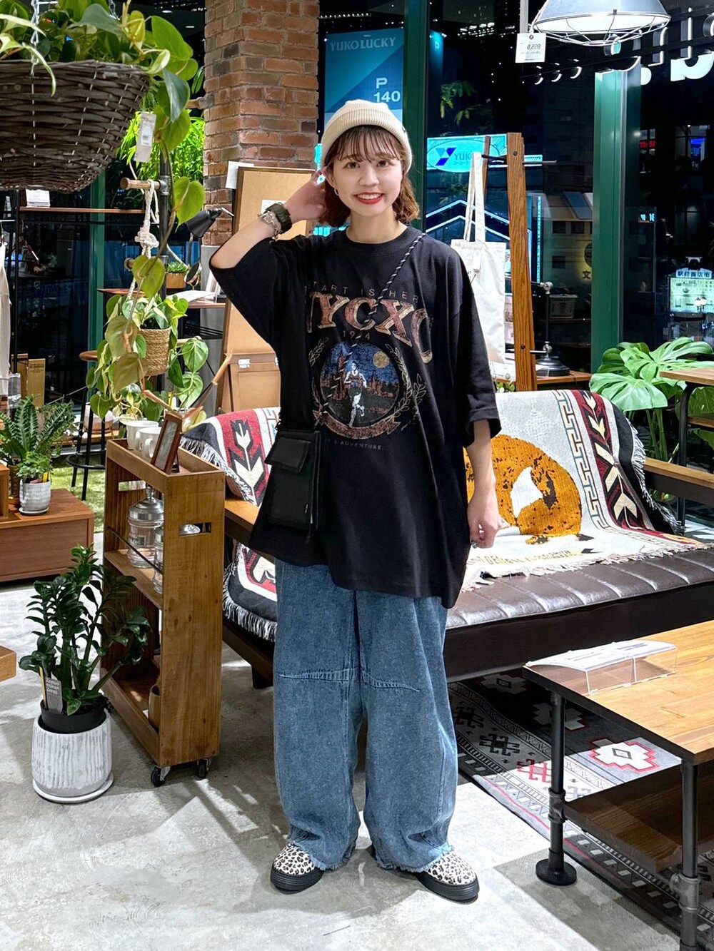 ブラック系のショルダーバッグ、ブルー系のデニムパンツ、ブラック系のTシャツ/カットソーを着用したレディースの夏コーディネートの3枚目の写真