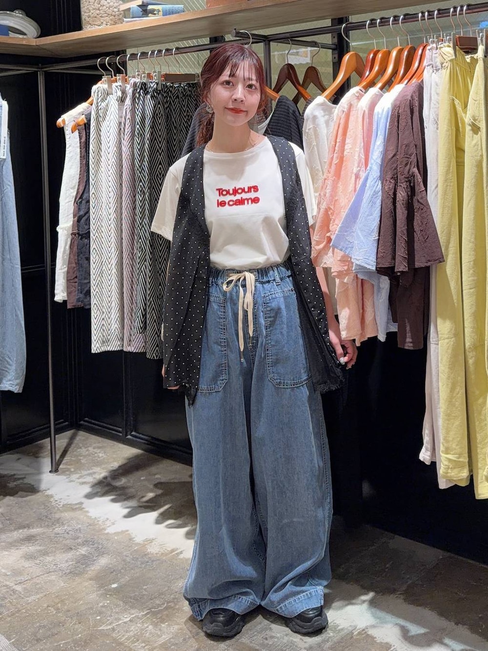 ブラック系のスニーカー、ブラック系のベスト、ホワイト系のTシャツ/カットソーを着用したレディースの夏コーディネートの7枚目の写真