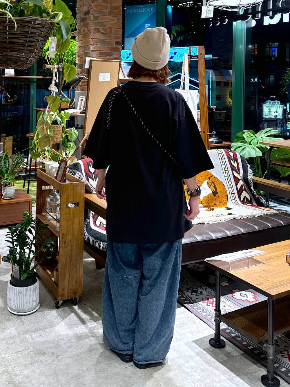 ブラック系のショルダーバッグ、ブルー系のデニムパンツ、ブラック系のTシャツ/カットソーを着用したレディースの夏コーディネートの5枚目の写真