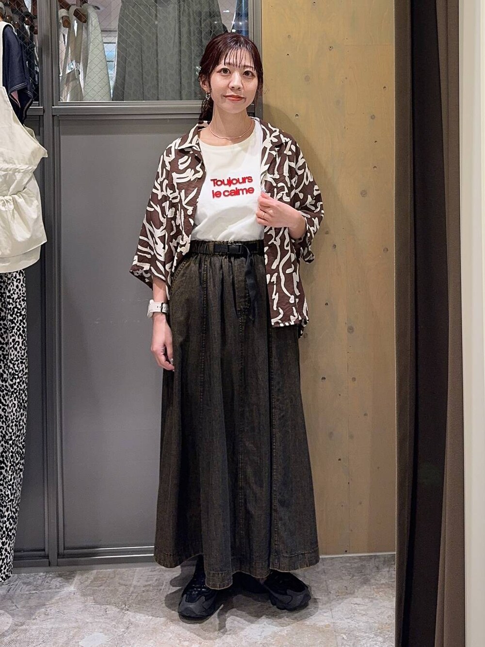 ブラウン系のスカート、ブラウン系のシャツ/ブラウス、ホワイト系のTシャツ/カットソーを着用したレディースの春コーディネートの6枚目の写真