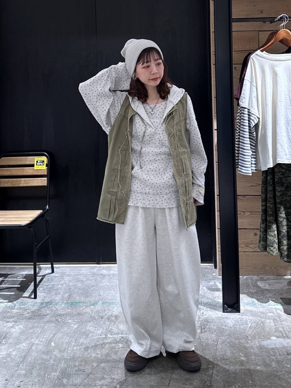 グリーン系のベスト、ベージュ系のパーカー、ブラウン系のローファーを着用したレディースの冬コーディネートの2枚目の写真