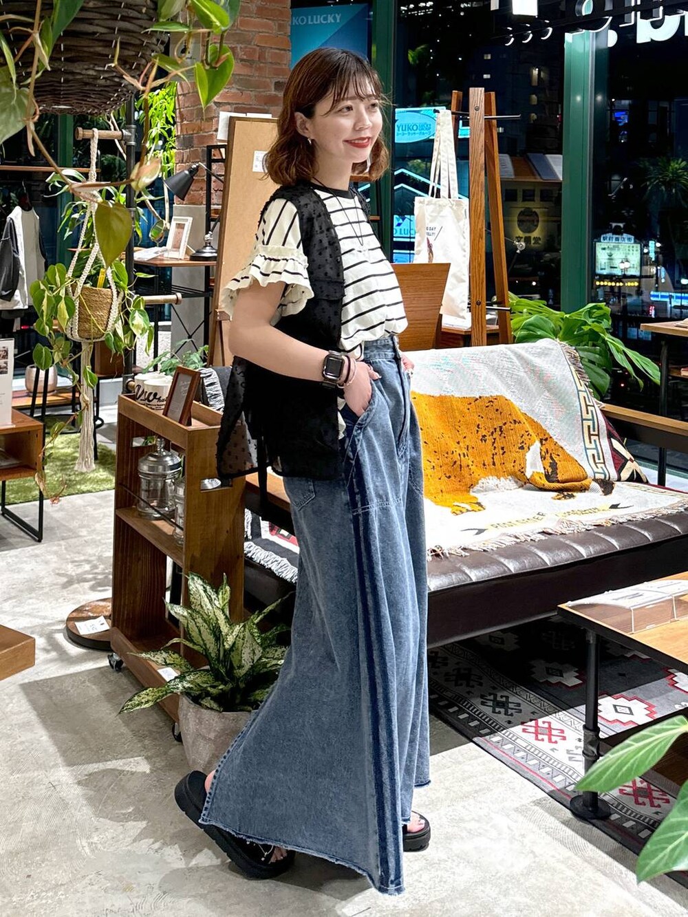 ブラック系のサンダル、ブラック系のベスト、ブルー系のスカートを着用したレディースの夏コーディネートの9枚目の写真