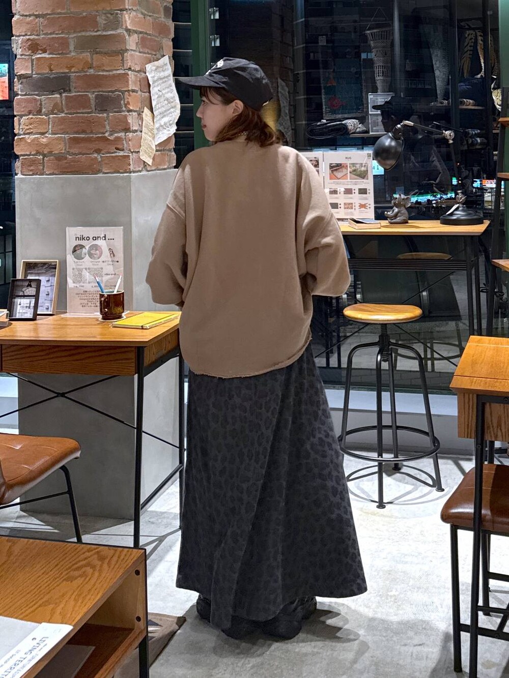 グレー系のスカート、イエロー系のスウェット、ブラック系のスニーカーを着用したレディースの秋コーディネートの3枚目の写真