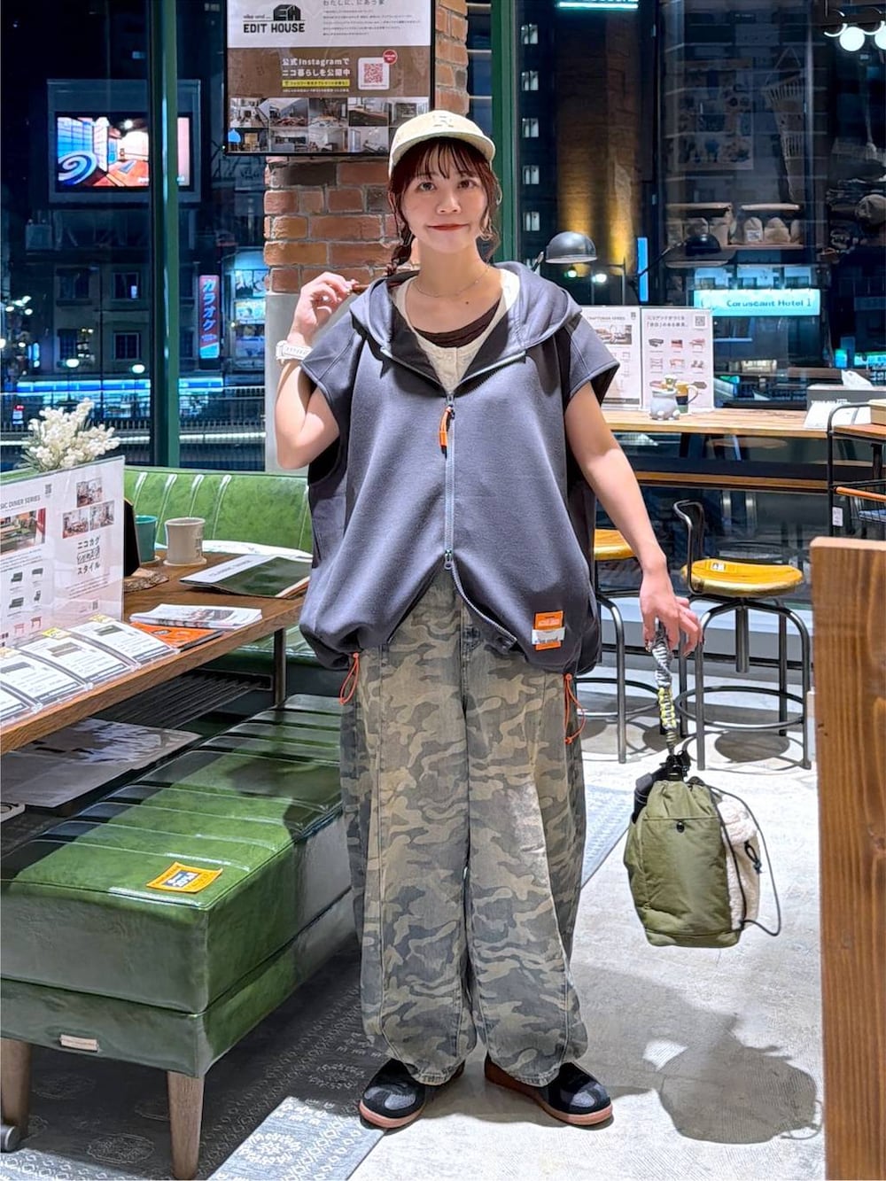 グレー系のベスト、グリーン系のデニムパンツ、グリーン系のショルダーバッグを着用したレディースの夏コーディネートの8枚目の写真