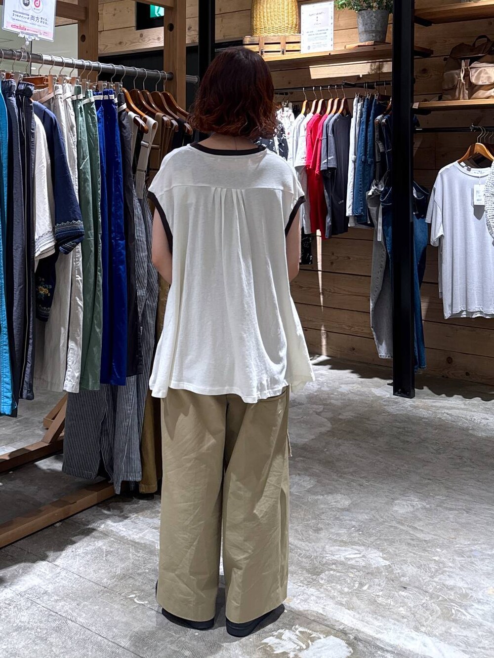 ベージュ系のチノパンツ、ホワイト系のTシャツ/カットソー、ブラック系のトートバッグを着用したレディースの夏コーディネートの3枚目の写真