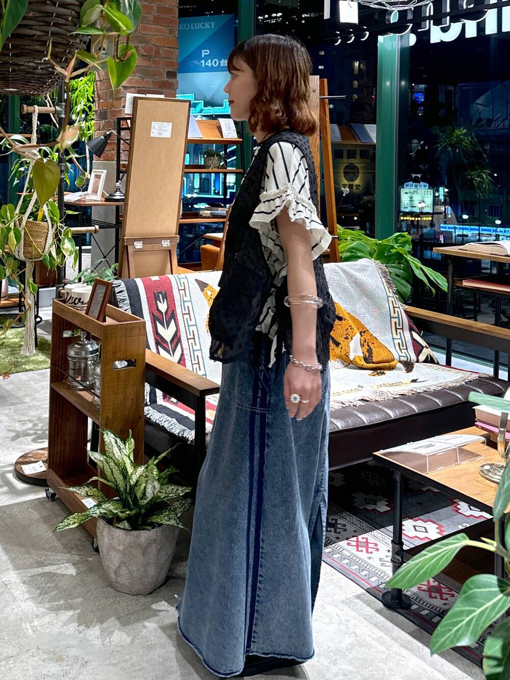 ブラック系のサンダル、ブラック系のベスト、ブルー系のスカートを着用したレディースの夏コーディネートの5枚目の写真