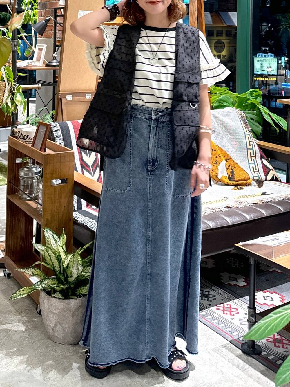 ブラック系のサンダル、ブラック系のベスト、ブルー系のスカートを着用したレディースの夏コーディネートの4枚目の写真