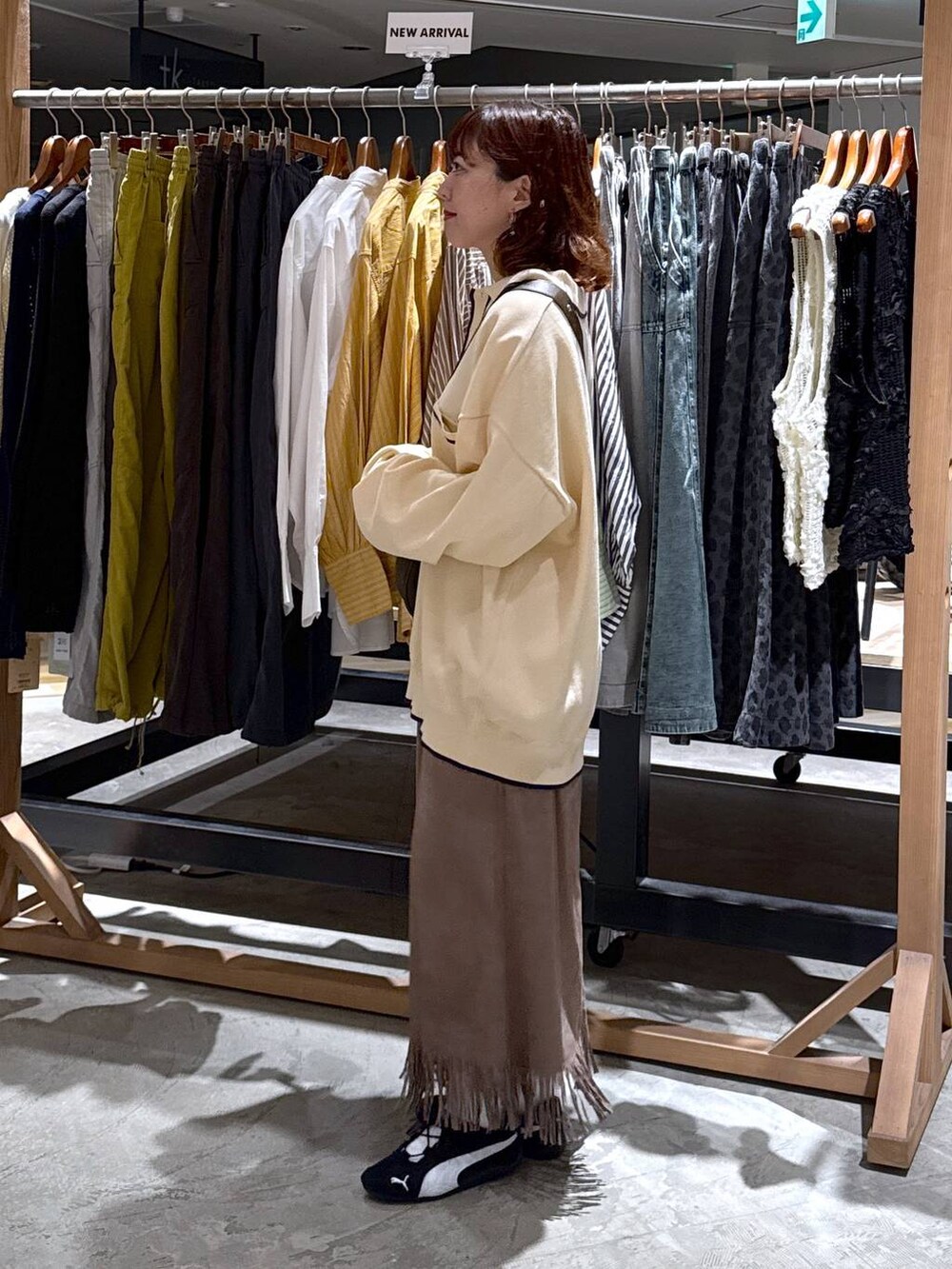 ブラウン系のショルダーバッグ、ブラウン系のスカートを着用したレディースの秋コーディネートの4枚目の写真