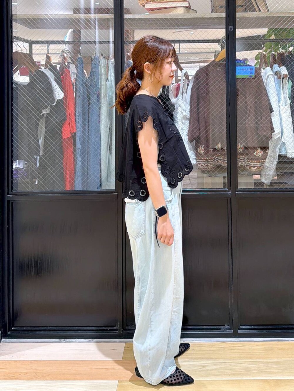 ブラック系のベスト、グリーン系のデニムパンツ、シルバー系のショルダーバッグを着用したレディースの夏コーディネートの6枚目の写真