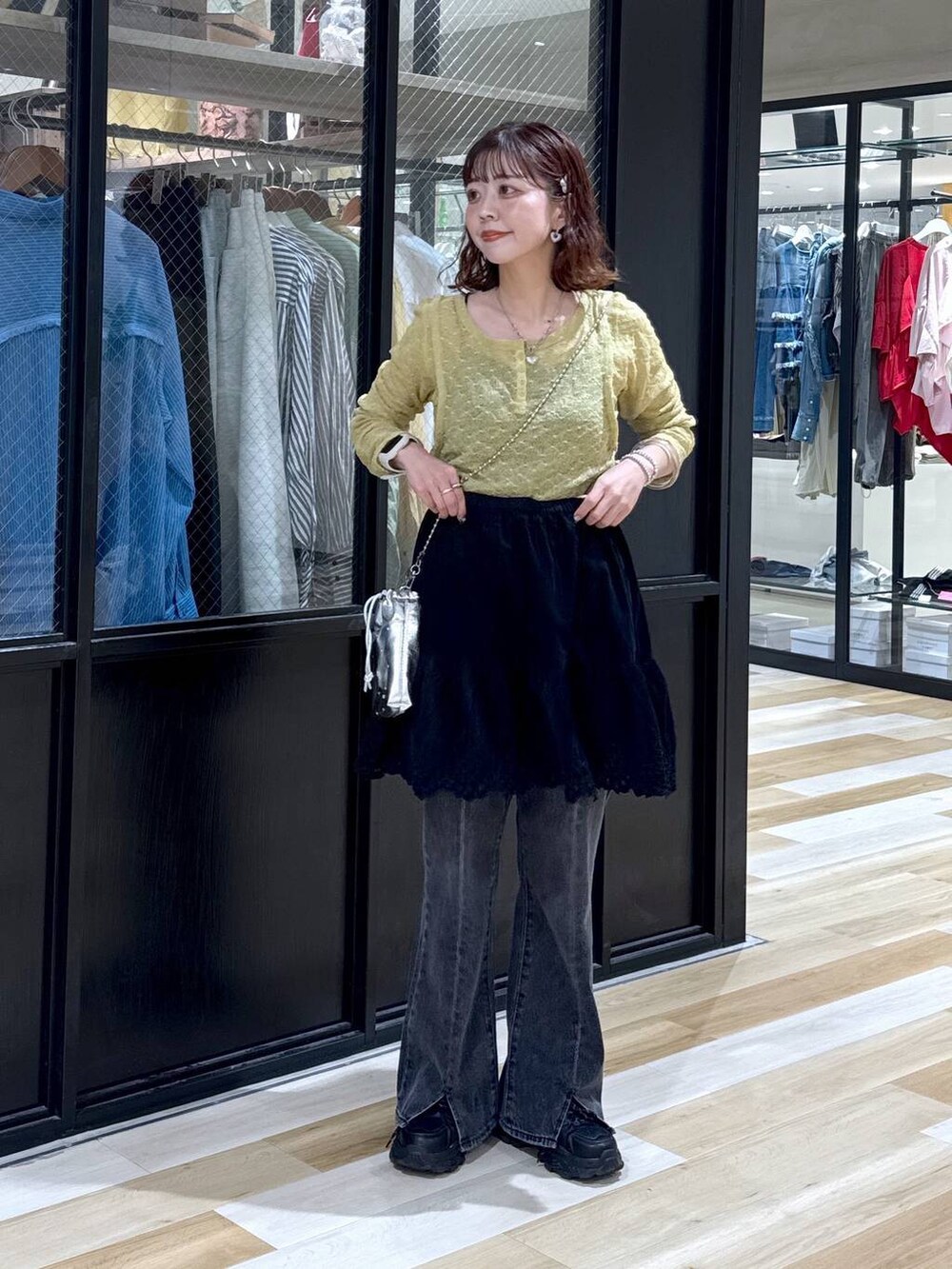 シルバー系のショルダーバッグ、グレー系のデニムパンツ、ブラック系のスニーカーを着用したレディースの夏コーディネートの8枚目の写真