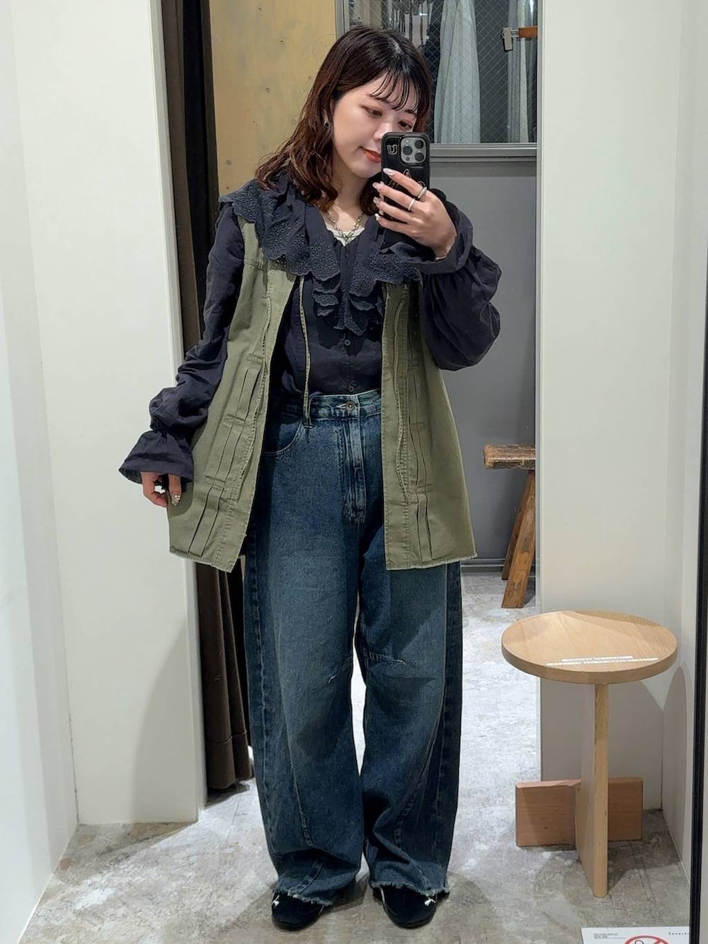 グリーン系のベスト、ブルー系のデニムパンツ、グレー系のシャツ/ブラウスを着用したレディースの冬コーディネートの2枚目の写真