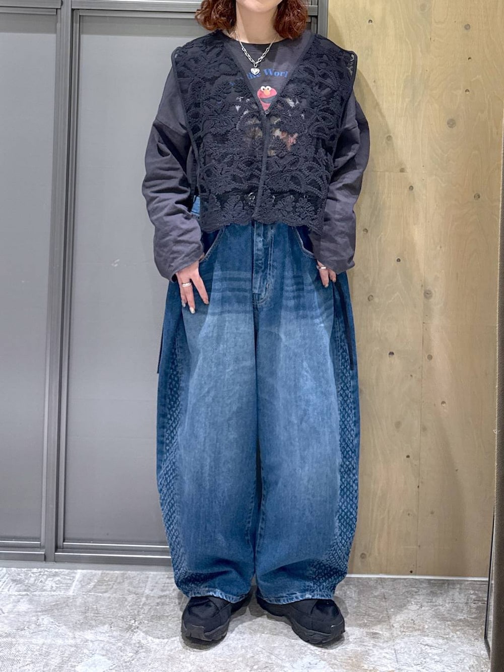 グレー系のTシャツ/カットソー、ブルー系のデニムパンツ、ブラック系のベストを着用したレディースの冬コーディネートの7枚目の写真