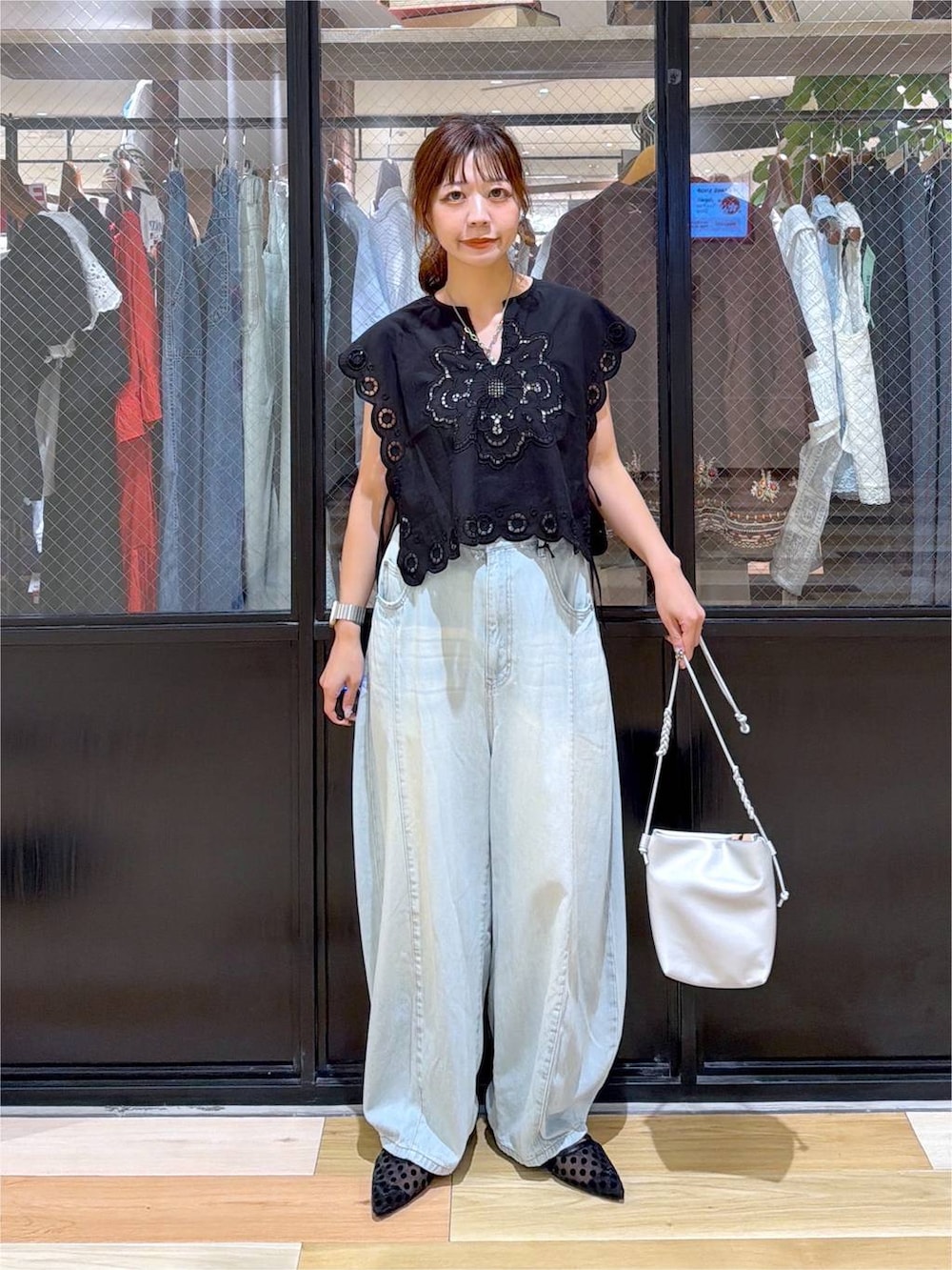 ブラック系のベスト、グリーン系のデニムパンツ、シルバー系のショルダーバッグを着用したレディースの夏コーディネートの7枚目の写真