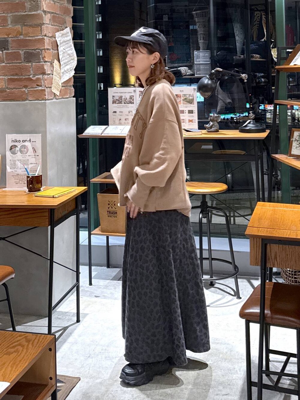 グレー系のスカート、イエロー系のスウェット、ブラック系のスニーカーを着用したレディースの秋コーディネートの2枚目の写真