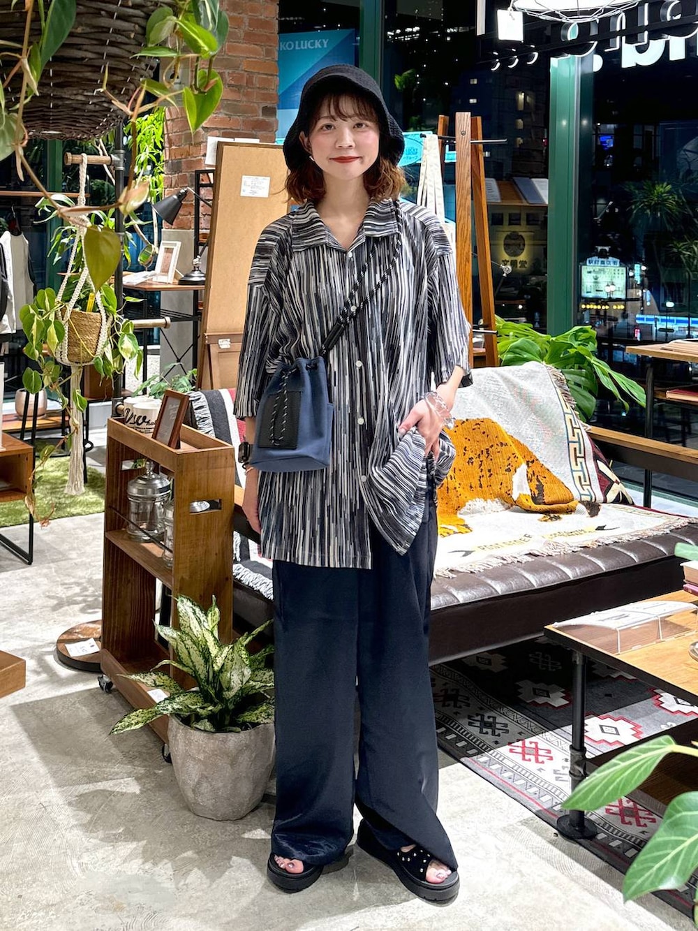 ブラック系のサンダル、ブルー系のショルダーバッグ、ブルー系のシャツ/ブラウスを着用したレディースの夏コーディネートの2枚目の写真