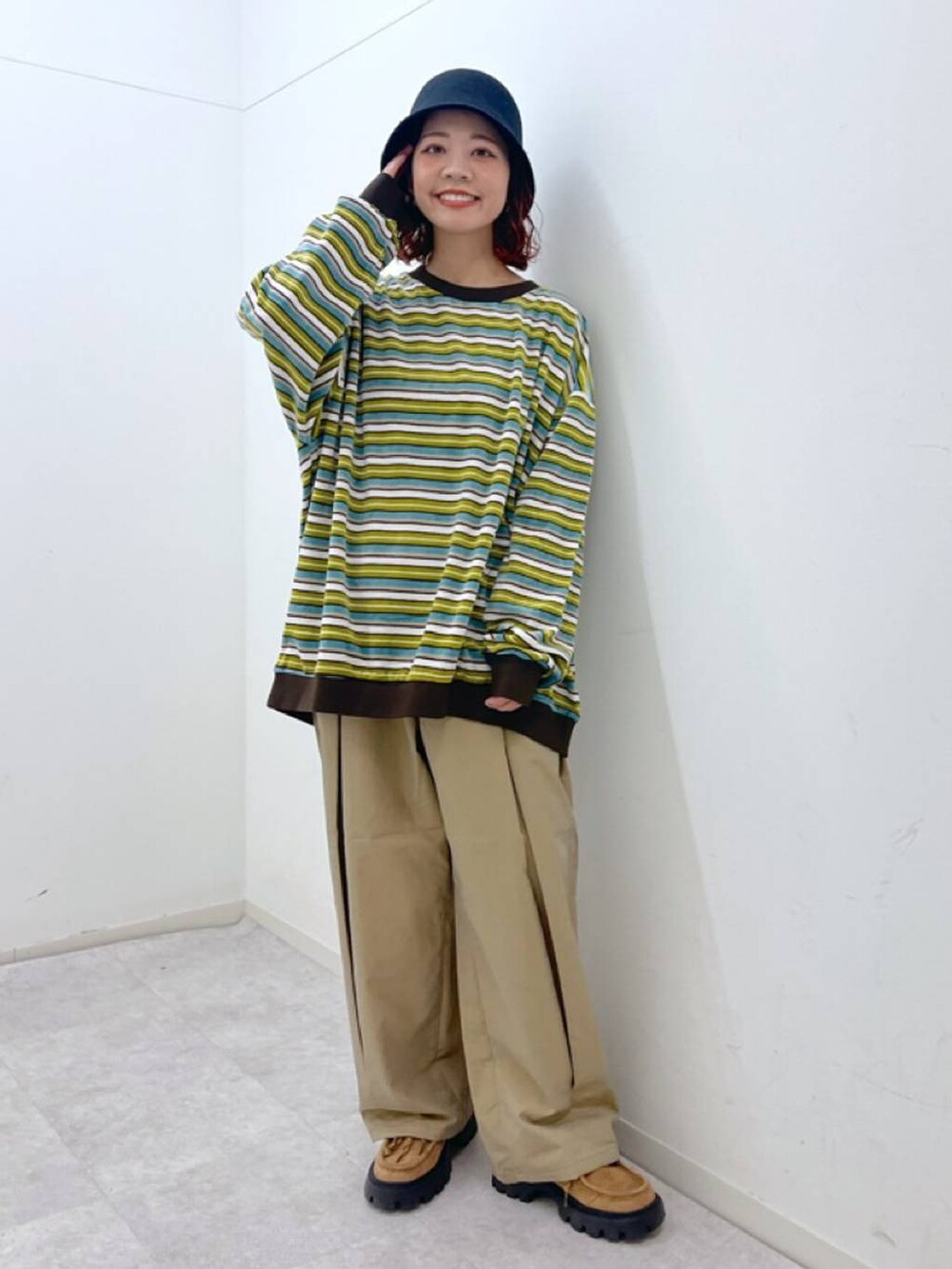 イエロー系のチノパンツ、イエロー系のモカシン/デッキシューズ、イエロー系のTシャツ/カットソーを着用したレディースの冬コーディネートの2枚目の写真