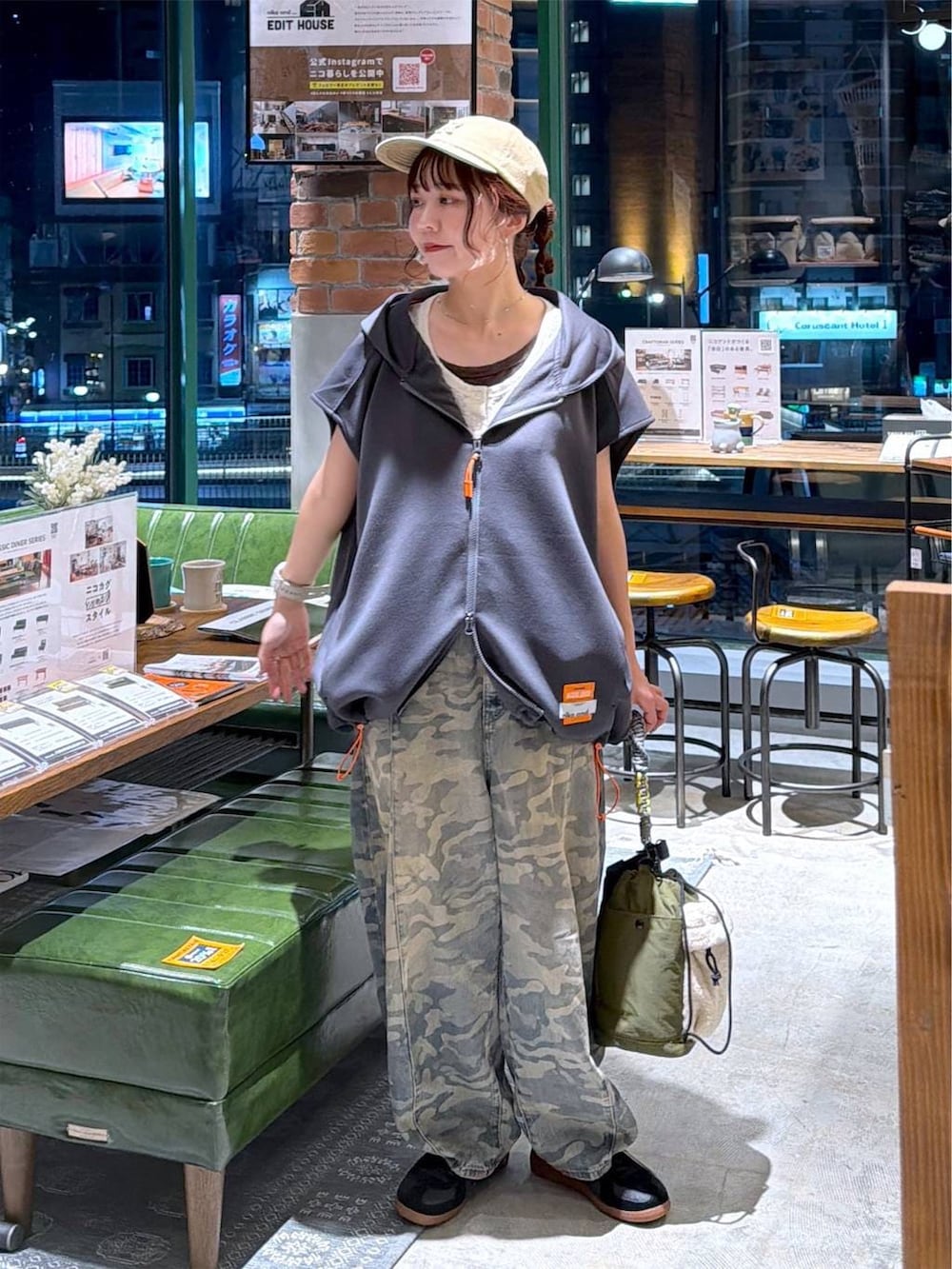 グレー系のベスト、グリーン系のデニムパンツ、グリーン系のショルダーバッグを着用したレディースの夏コーディネートの6枚目の写真