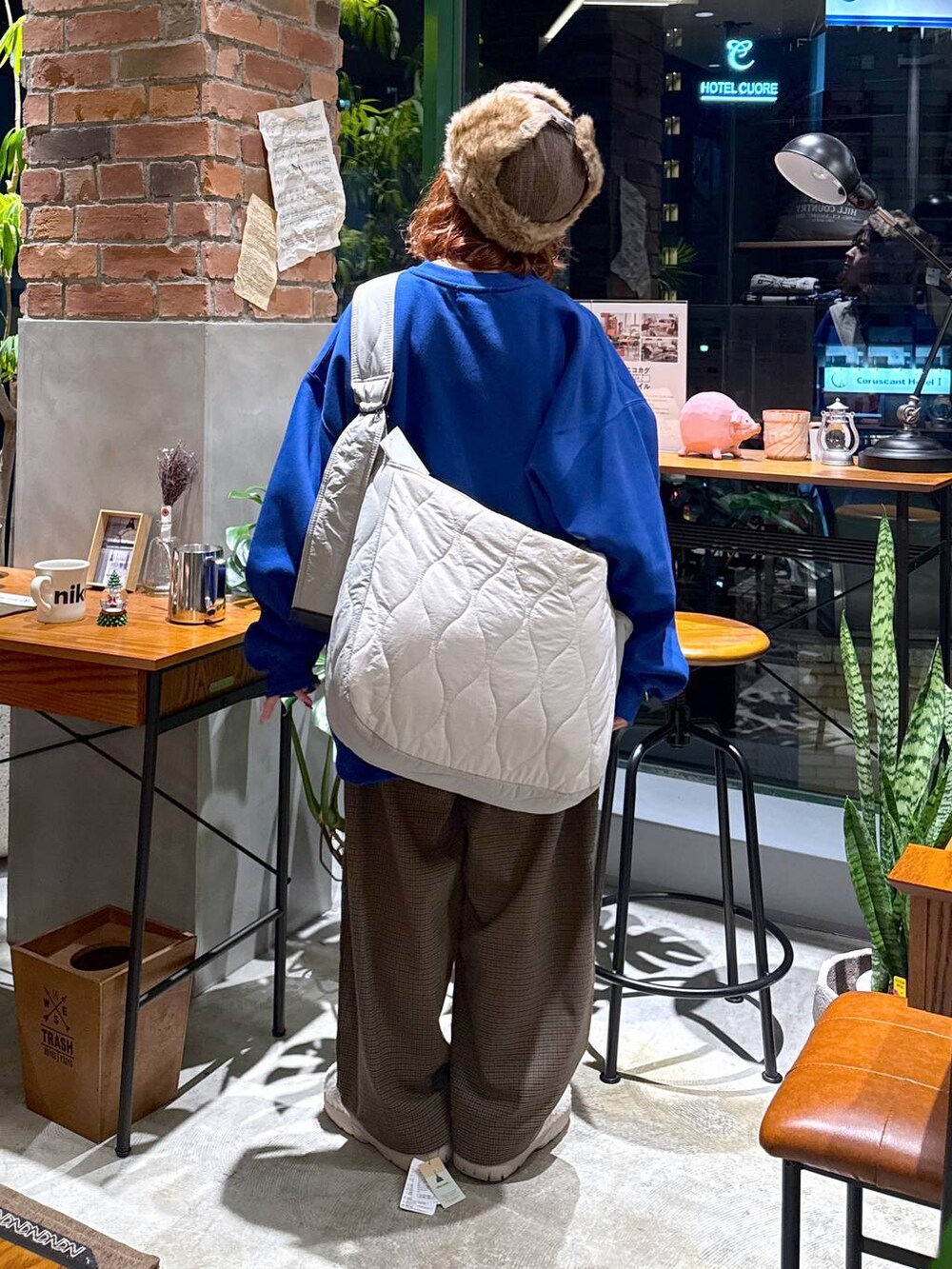 ブラウン系のその他パンツ、ブルー系のスウェット、ホワイト系のショルダーバッグを着用したレディースの冬コーディネートの3枚目の写真