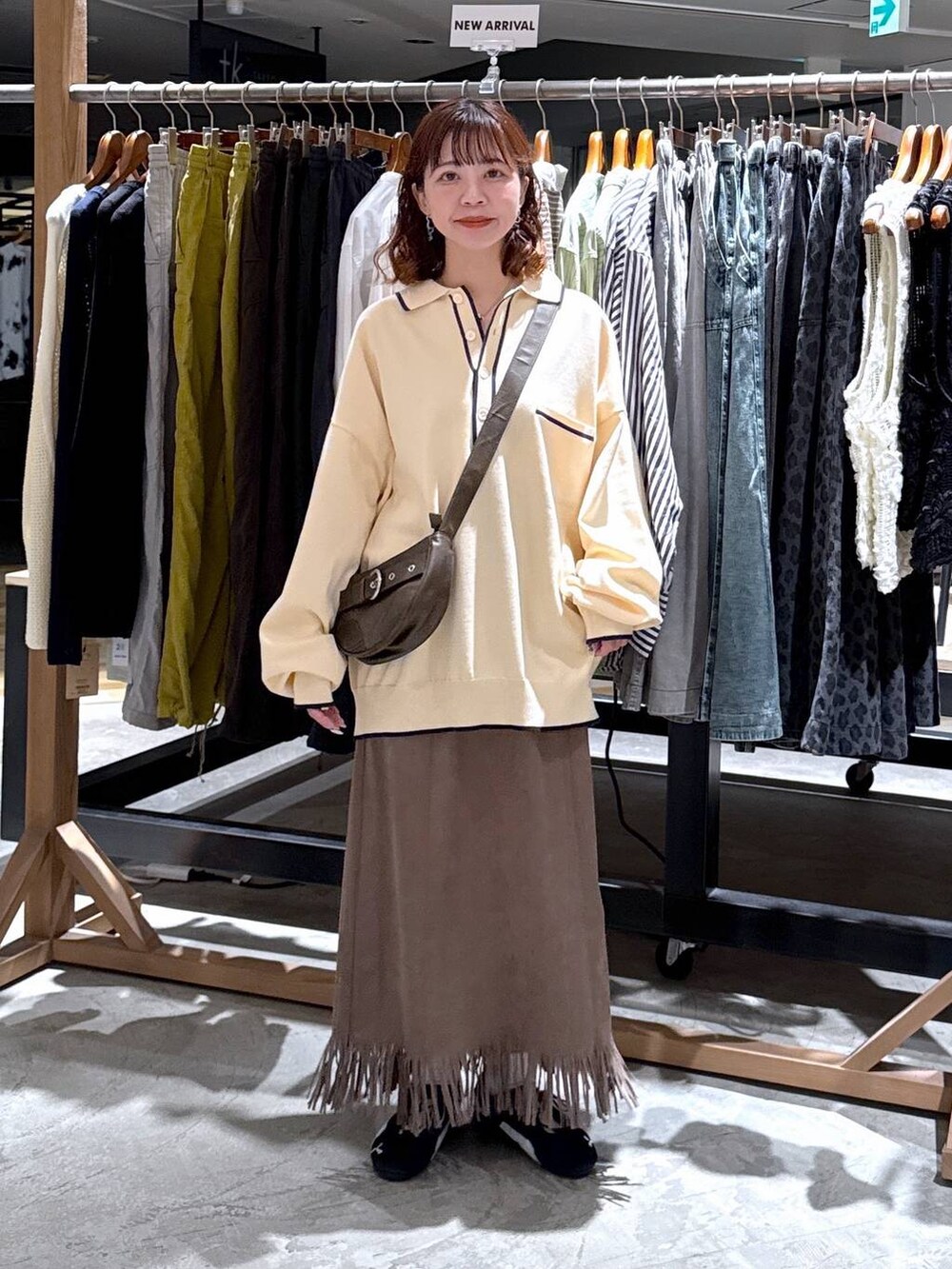 ブラウン系のショルダーバッグ、ブラウン系のスカートを着用したレディースの秋コーディネートの2枚目の写真