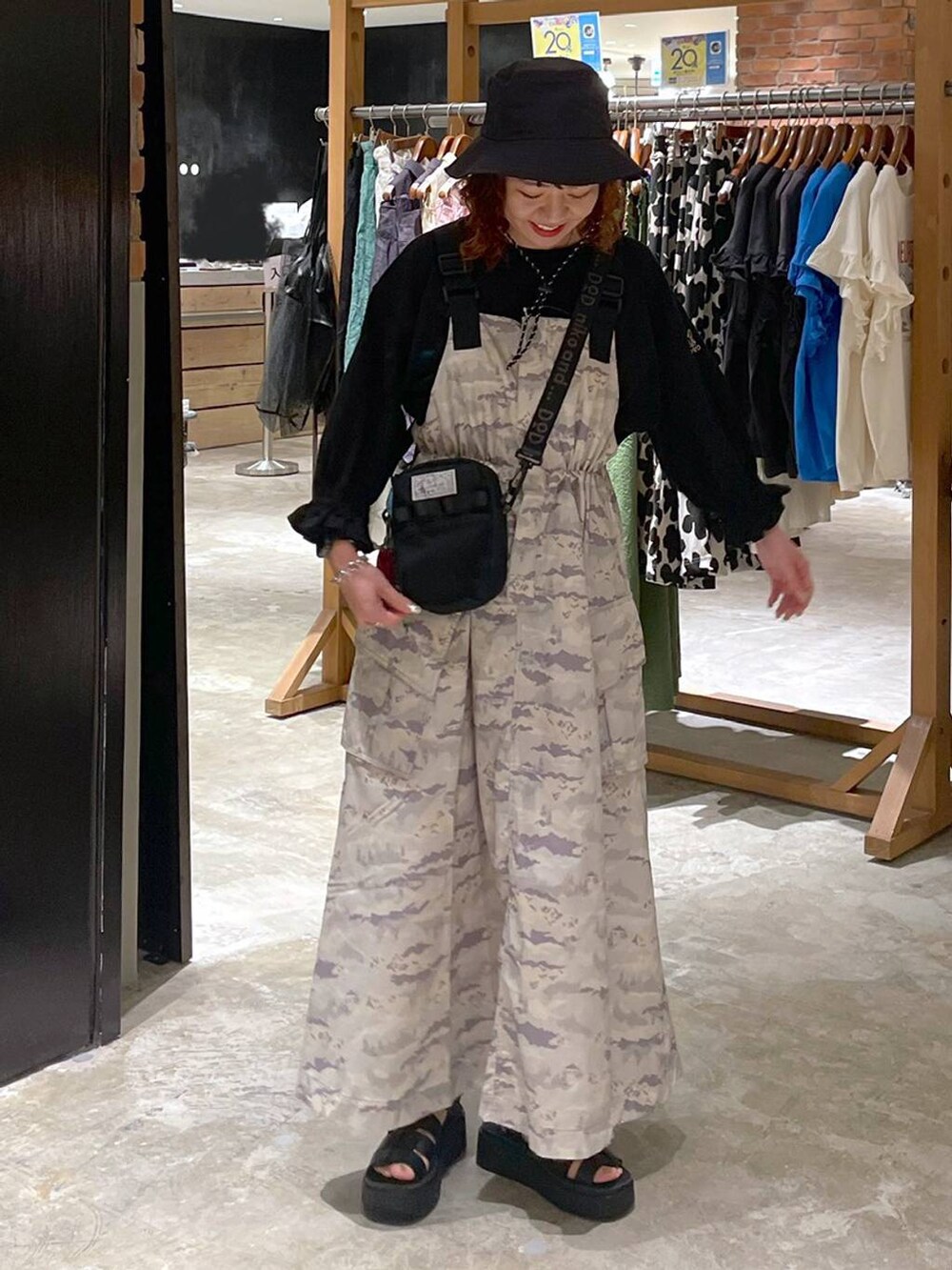 ブラック系のサンダル、ブラック系のTシャツ/カットソー、グリーン系のジャンパースカートを着用したレディースの春コーディネートの8枚目の写真