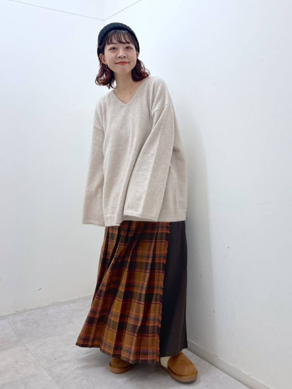 オレンジ系のスカート、ベージュ系のニット/セーター、イエロー系のその他シューズを着用したレディースの冬コーディネートの4枚目の写真