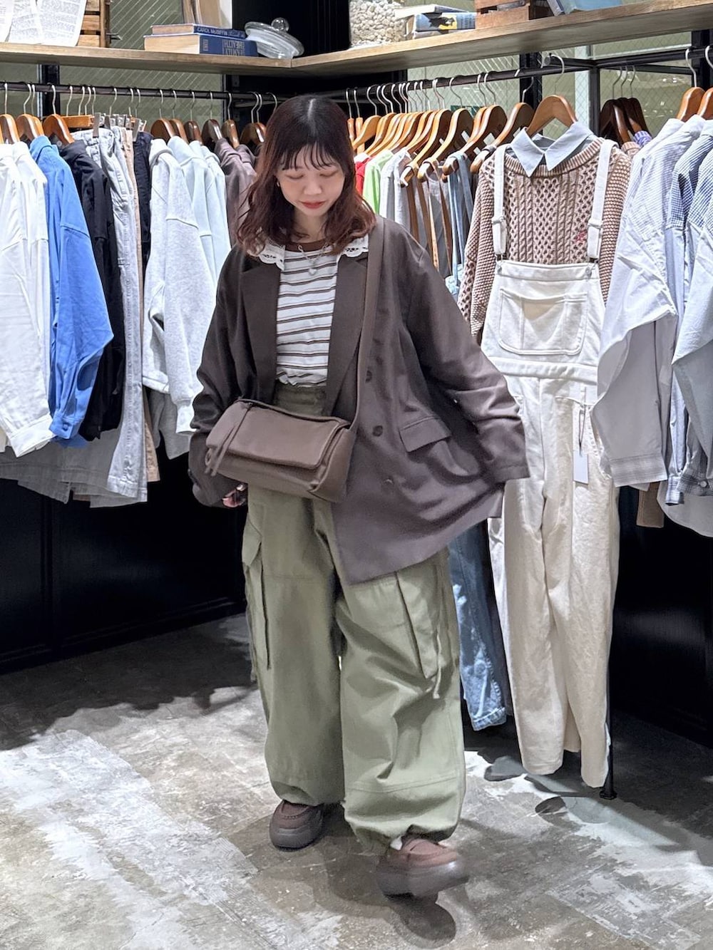 ブラウン系のショルダーバッグ、グリーン系のカーゴパンツ、ブルー系のTシャツ/カットソーを着用したレディースの冬コーディネートの8枚目の写真