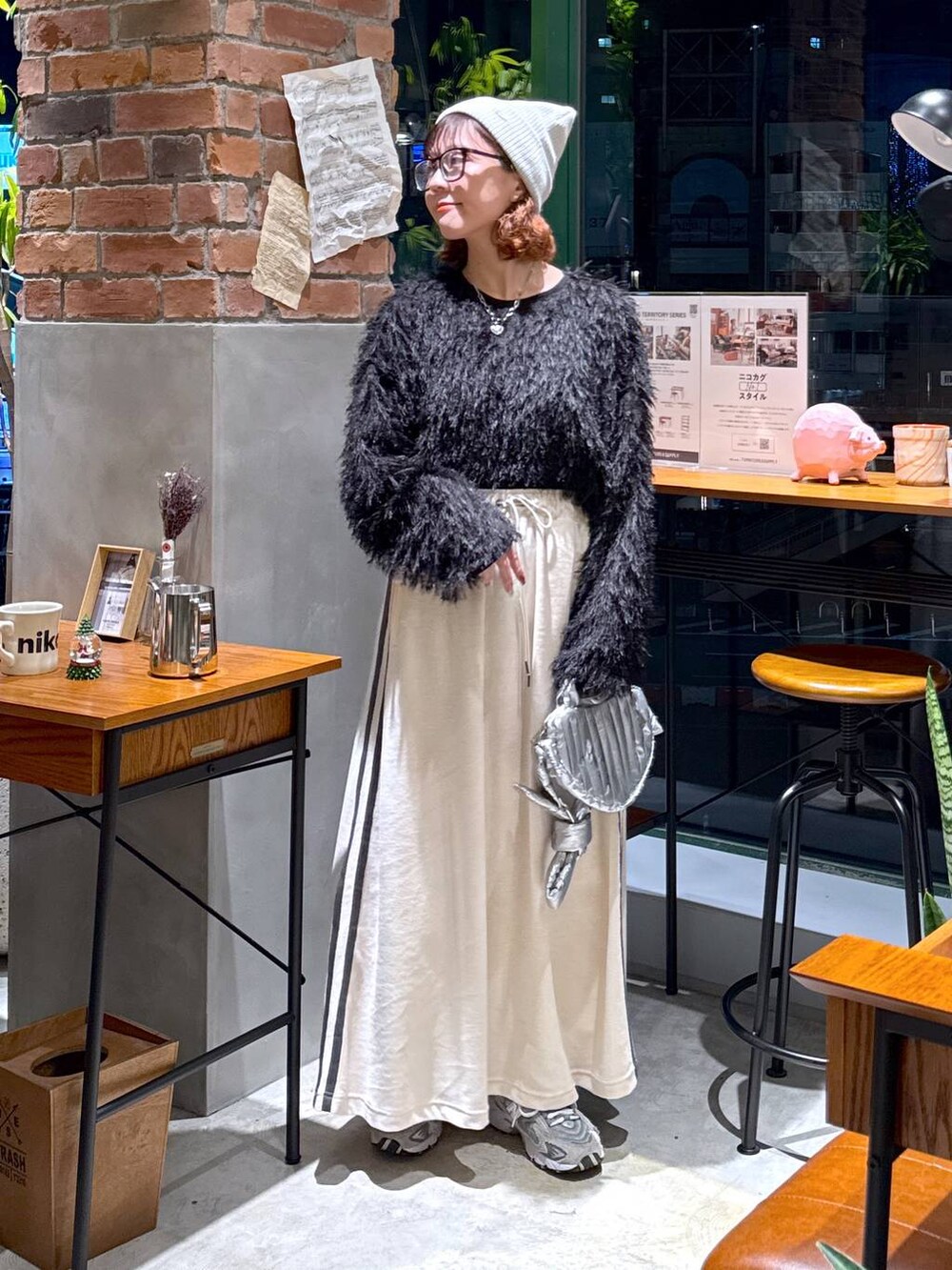 シルバー系のショルダーバッグ、ブラック系のその他トップス、ベージュ系のスカートを着用したレディースの冬コーディネートの8枚目の写真