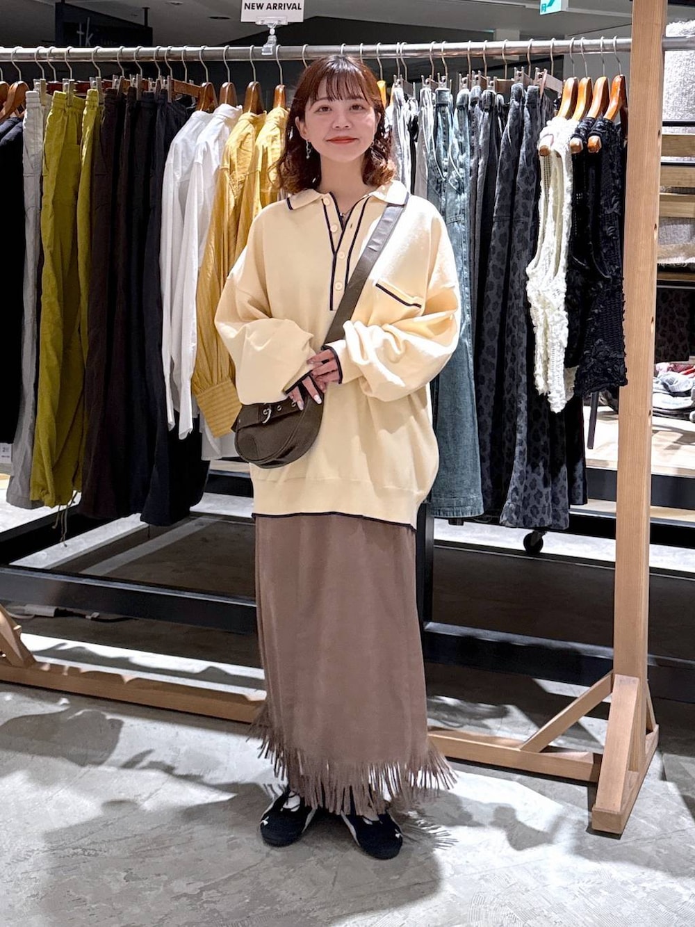 ブラウン系のショルダーバッグ、ブラウン系のスカートを着用したレディースの秋コーディネートの3枚目の写真