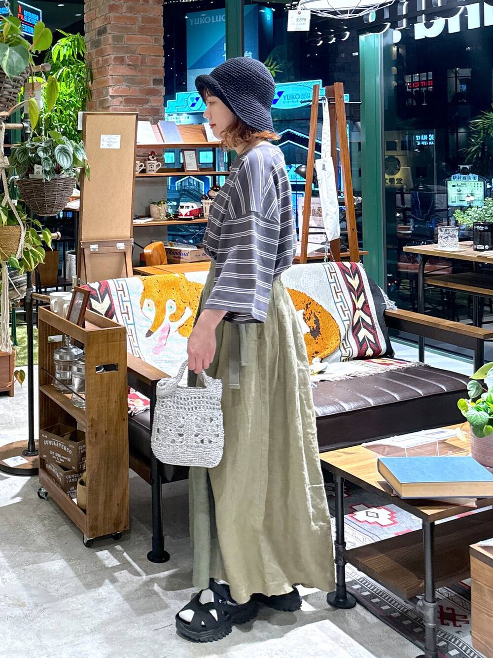 グレー系のショルダーバッグ、ブラック系のサンダル、グレー系のTシャツ/カットソーを着用したレディースの春コーディネートの5枚目の写真