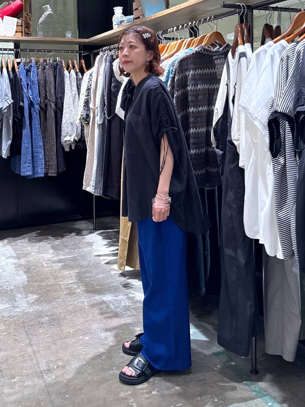 グレー系のタンクトップ、ブラック系のサンダル、ブルー系のその他パンツを着用したレディースの夏コーディネートの3枚目の写真