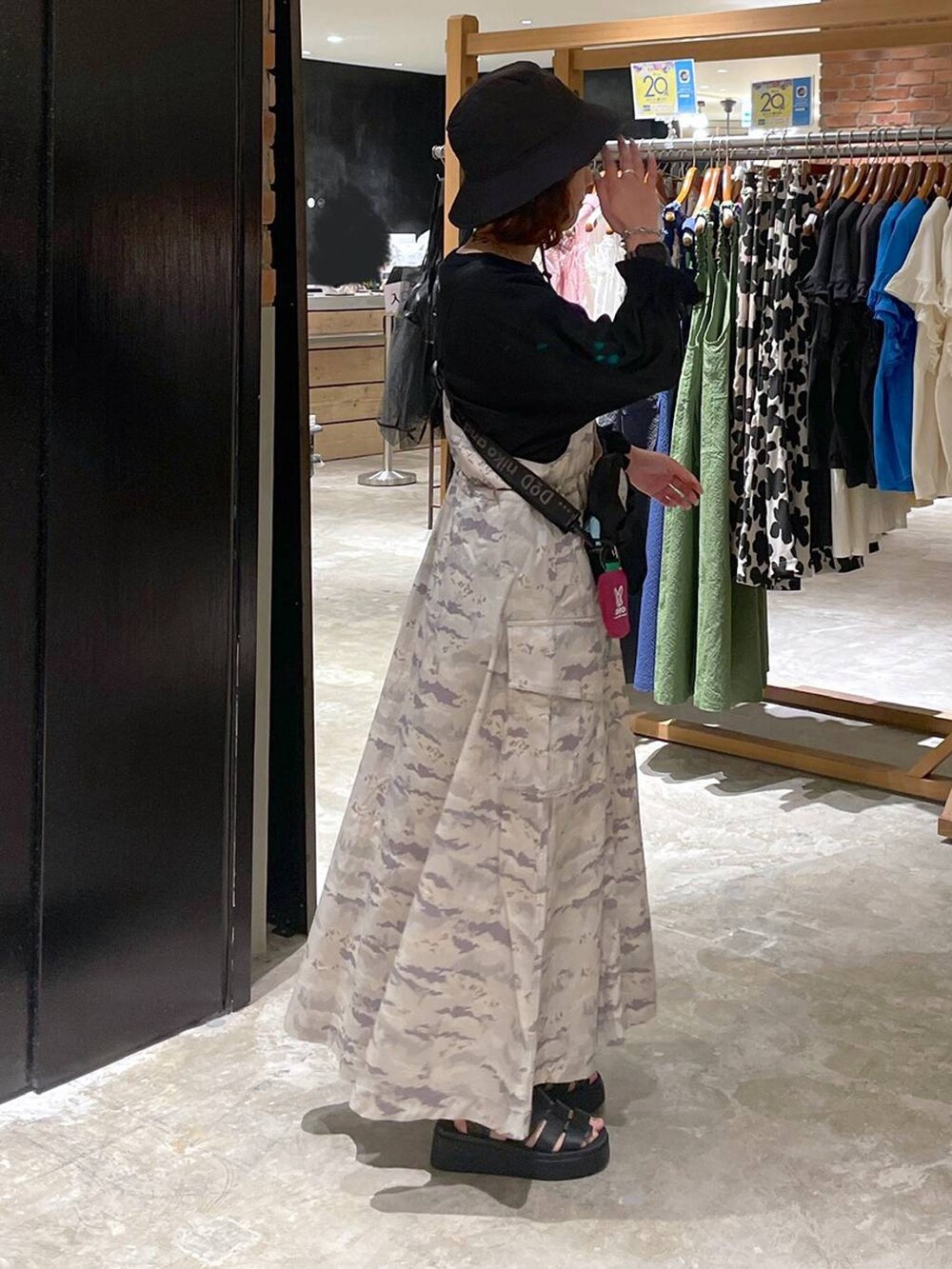 ブラック系のサンダル、ブラック系のTシャツ/カットソー、グリーン系のジャンパースカートを着用したレディースの春コーディネートの4枚目の写真