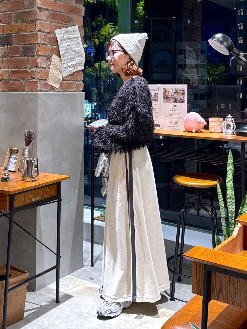 シルバー系のショルダーバッグ、ブラック系のその他トップス、ベージュ系のスカートを着用したレディースの冬コーディネートの5枚目の写真