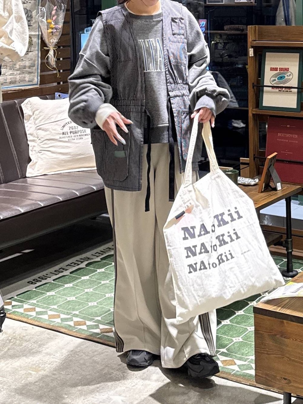 グレー系のエコバッグ/サブバッグ、グレー系のベスト、グレー系のTシャツ/カットソーを着用したレディースの冬コーディネートの6枚目の写真