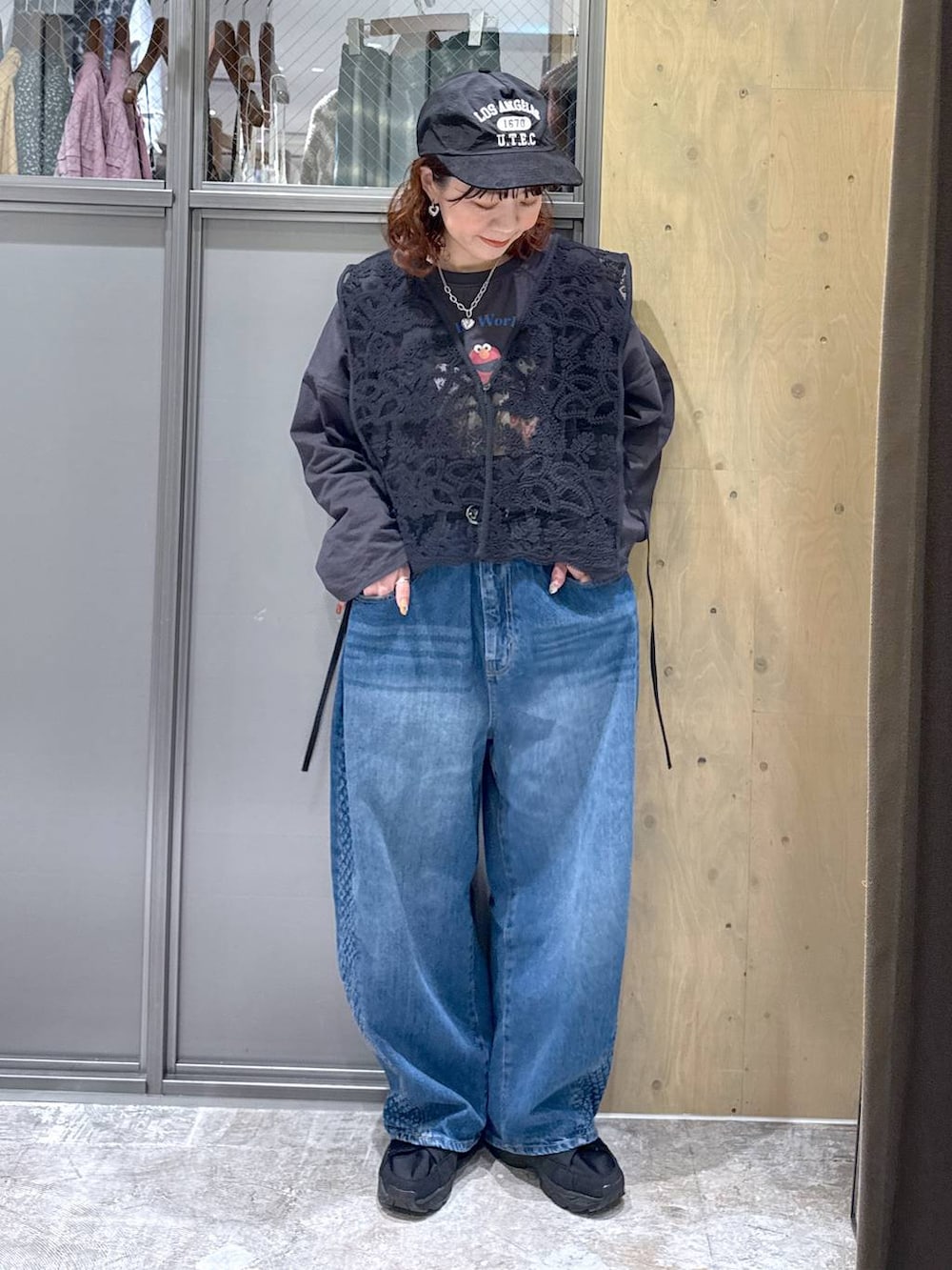 グレー系のTシャツ/カットソー、ブルー系のデニムパンツ、ブラック系のベストを着用したレディースの冬コーディネートの2枚目の写真