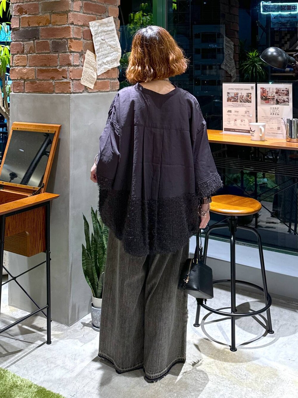 ブラック系のバレエシューズ、ブラック系のショルダーバッグ、ブラウン系のデニムパンツを着用したレディースの秋コーディネートの8枚目の写真