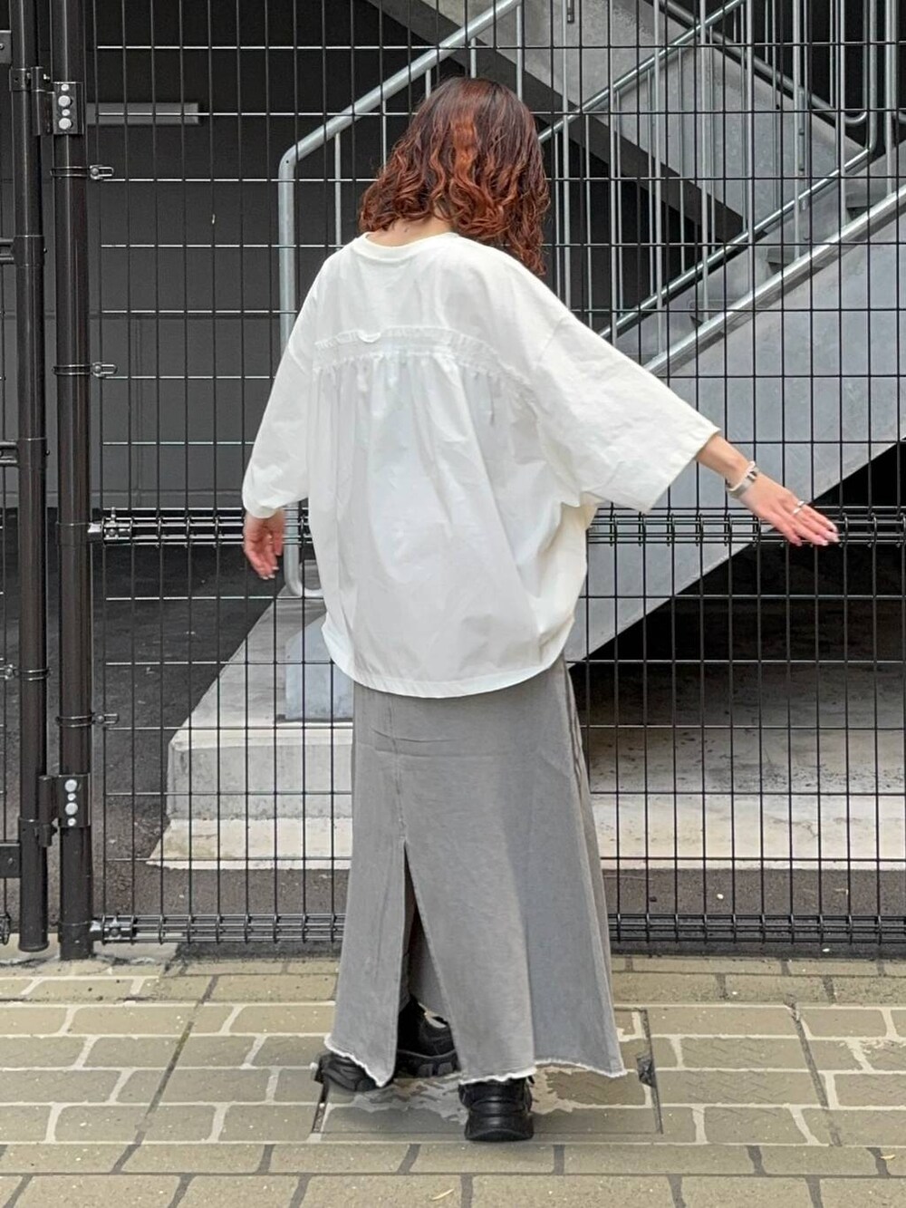 グリーン系のシャツ/ブラウス、オレンジ系のバックパック/リュック、ホワイト系のTシャツ/カットソーを着用したレディースの春コーディネートの9枚目の写真