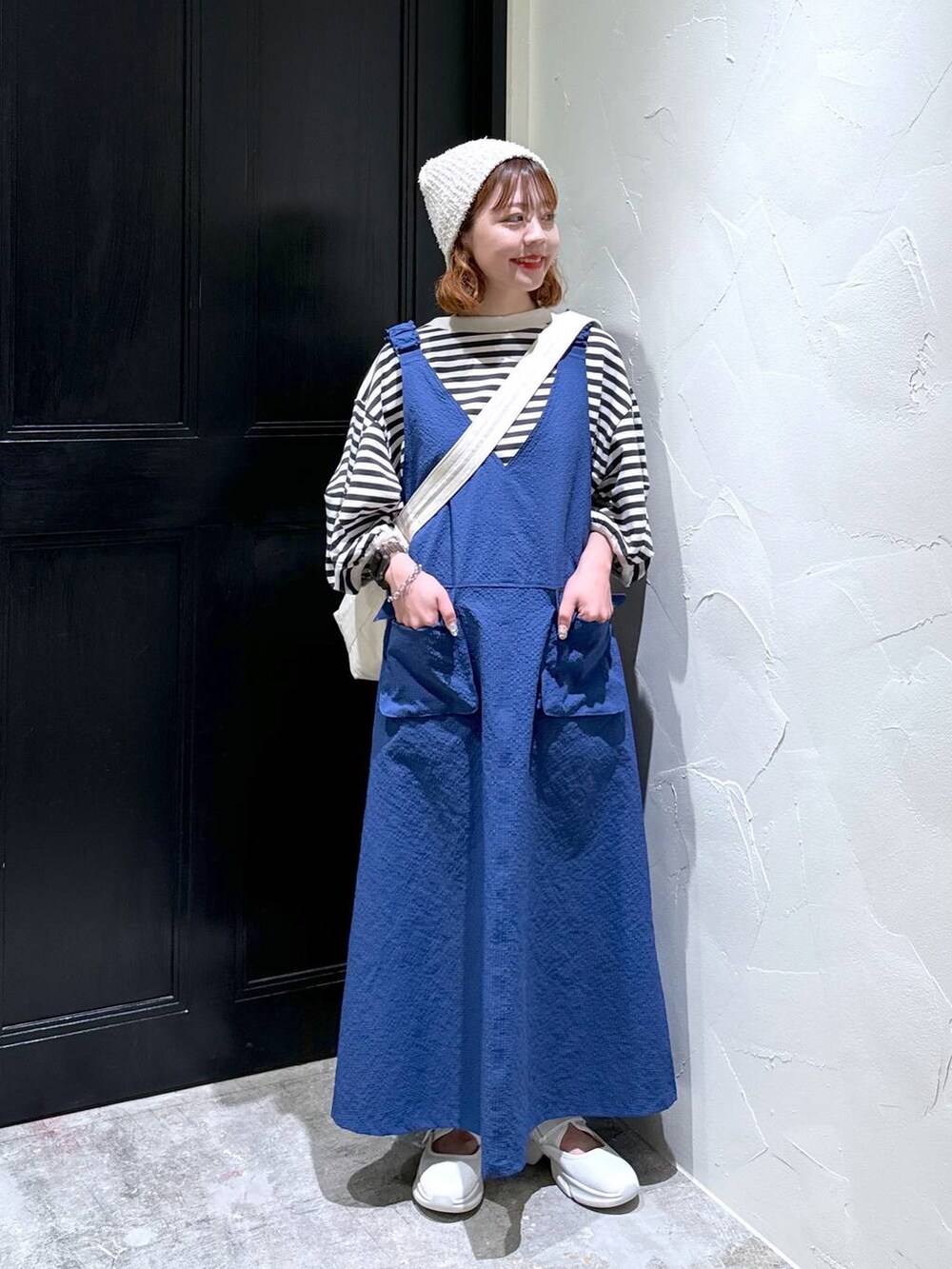 ブルー系のジャンパースカート、ベージュ系のスニーカー、ブラウン系のショルダーバッグを着用したレディースの夏コーディネートの8枚目の写真