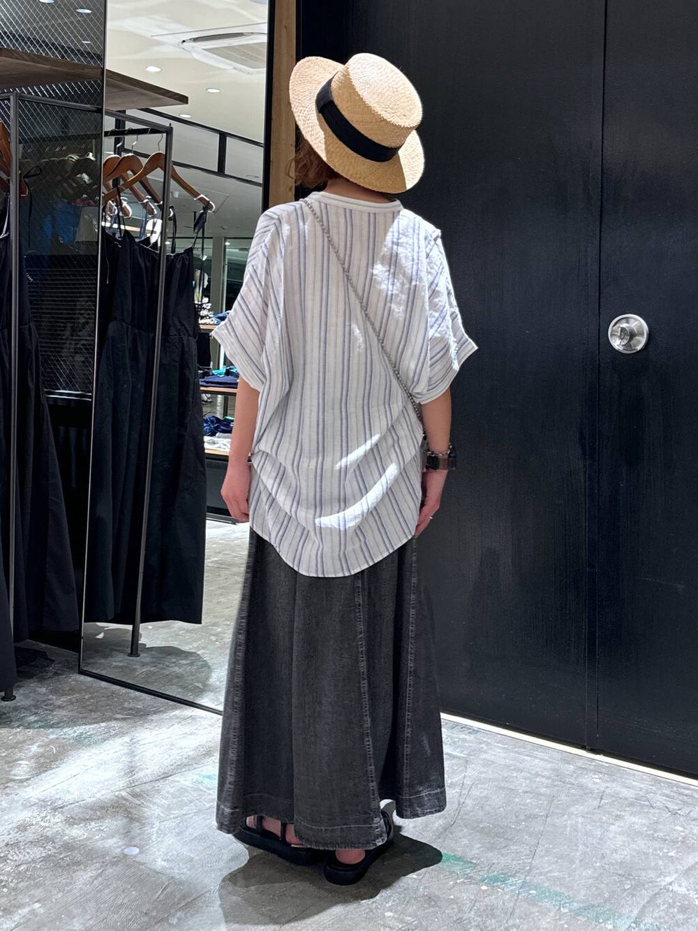 ブラック系のショルダーバッグ、ブラック系のサンダル、ベージュ系のシャツ/ブラウスを着用したレディースの夏コーディネートの4枚目の写真