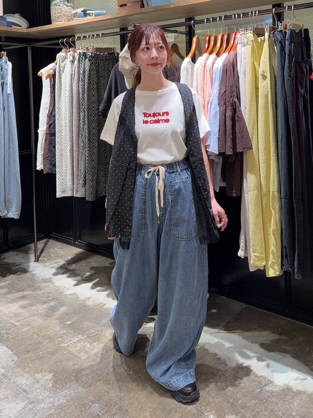 ブラック系のスニーカー、ブラック系のベスト、ホワイト系のTシャツ/カットソーを着用したレディースの夏コーディネートの8枚目の写真