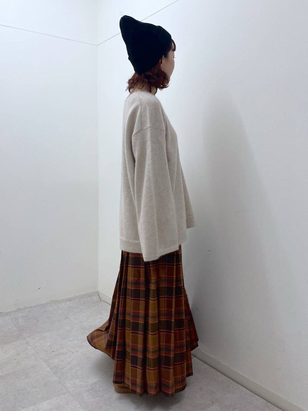 オレンジ系のスカート、ベージュ系のニット/セーター、イエロー系のその他シューズを着用したレディースの冬コーディネートの9枚目の写真