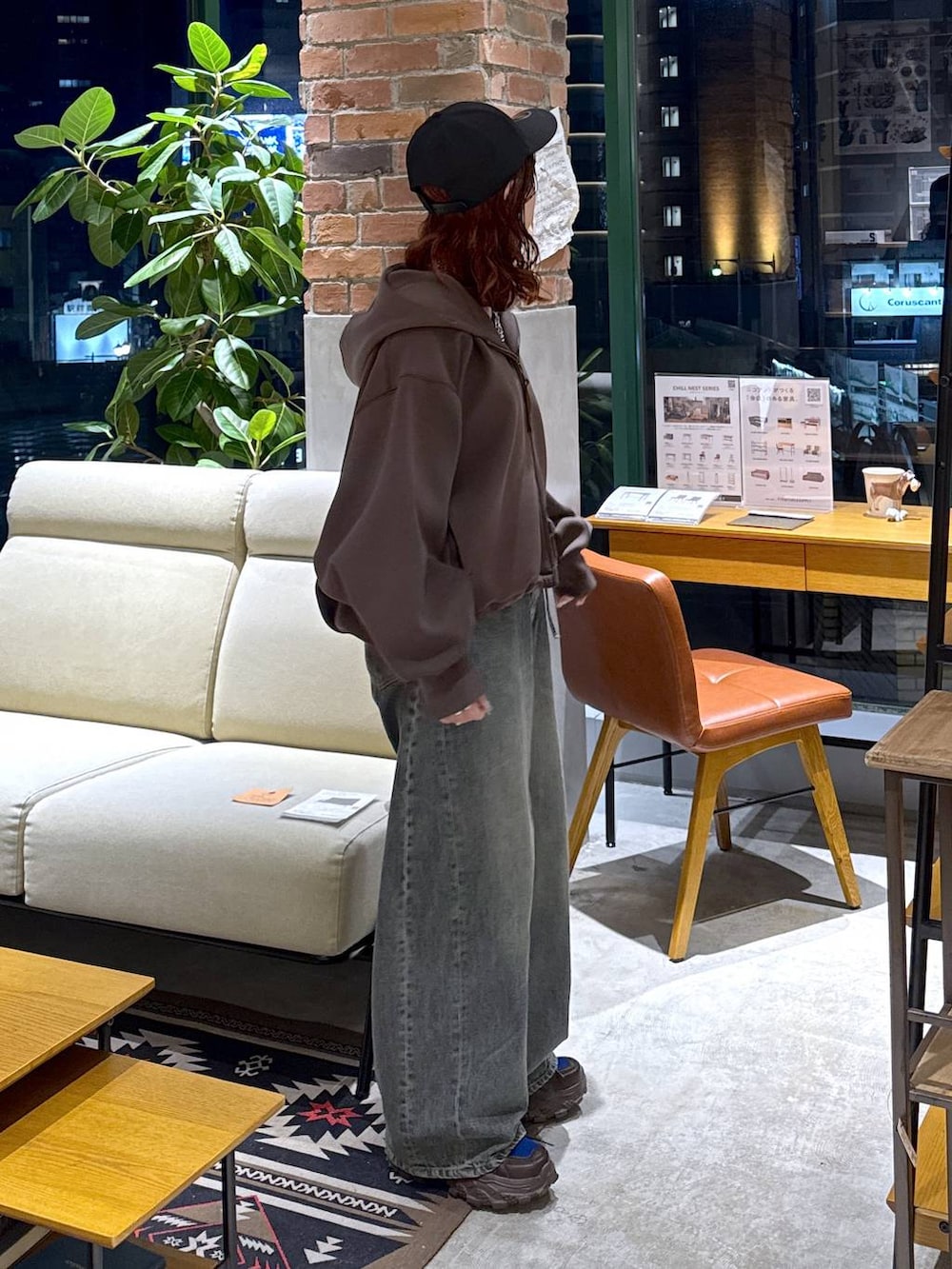 ブラウン系のスニーカー、ブルー系のデニムパンツ、ブラウン系のパーカーを着用したレディースの冬コーディネートの6枚目の写真