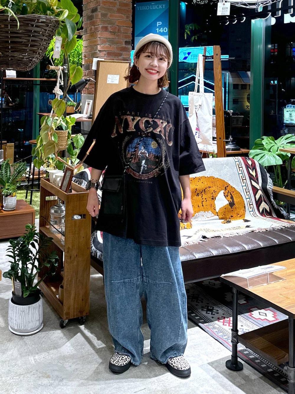 ブラック系のショルダーバッグ、ブルー系のデニムパンツ、ブラック系のTシャツ/カットソーを着用したレディースの夏コーディネートの2枚目の写真